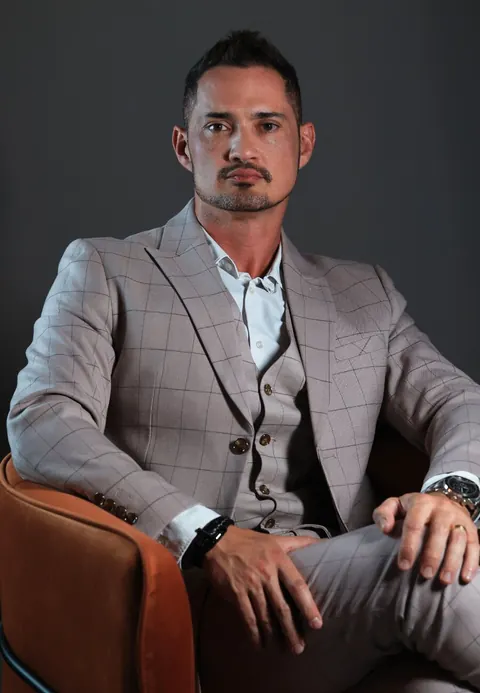 Dr. Sharbo Casagrande, de terno claro, sentado numa poltrona de couro